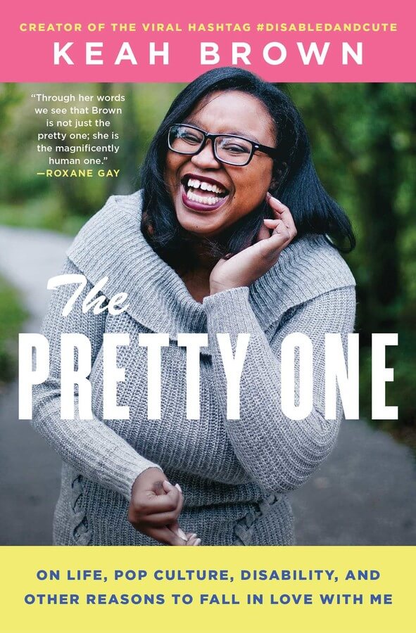 A black woman on a book cover with shoulder length hair wearing a grey sweater and black rectangle framed glasses. She's smiling, the title of the book is  “The Pretty One: On Life, Pop Culture, Disability, and Other Reasons to Fall in Love with Me”